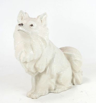 a white dog figurine sitting on a white surface
