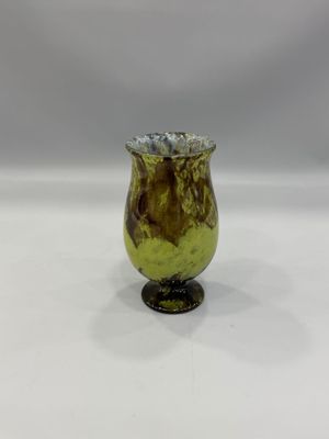un vase en verre jaune et marron posé sur une table blanche