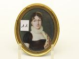 un portrait ovale représentant une femme en robe noire, dans un cadre doré