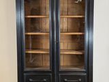 an antique black bookcase with glass doors in a living room