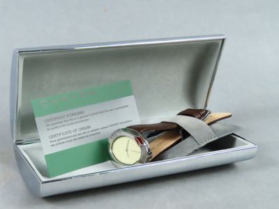une boîte en argent contenant une montre et une carte