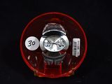 a watch sitting in a plastic container on a black surface