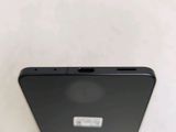 the back of a black cell phone sitting on top of a white table