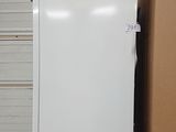 a white refrigerator sitting in a garage next to a cardboard box