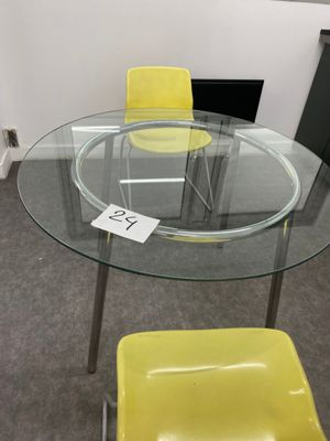 une table en verre avec une chaise jaune et une chaise jaune