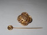 une broche en or munie d'une épingle