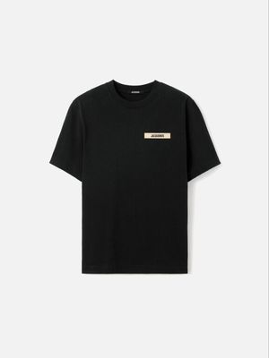 un t-shirt noir avec un écusson doré sur la poitrine