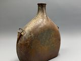 a large brown vase sitting on a white surface