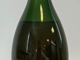 une bouteille de champagne posée sur une surface blanche, avec un fond blanc