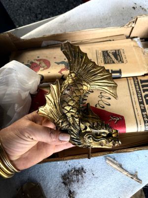 une personne tenant une boîte sur laquelle est représenté un dragon doré