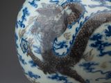 a blue and white vase with a dragon on it