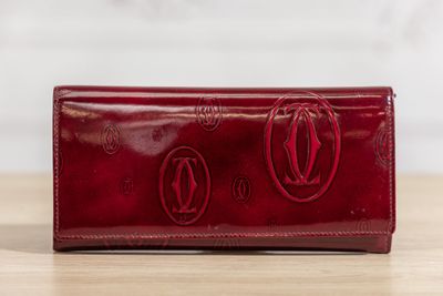 un portefeuille en cuir rouge avec deux cercles sur le devant et deux cercles au dos
