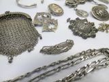 a lot of silver jewelry on a white table