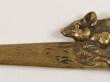 a small brass spoon with a mouse on it