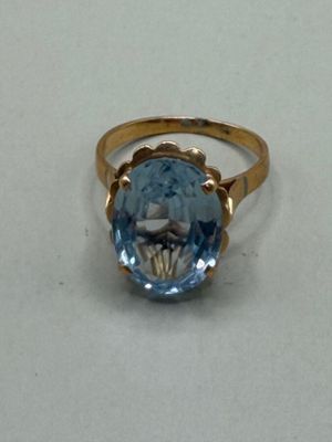 une image d'une bague avec une pierre en topaze bleue