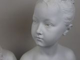 two white marble busts of a boy and a girl
