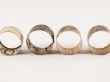four different types of silver rings on a white background