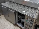 une cuisine équipée d'un plan de travail, d'un réfrigérateur et d'un évier