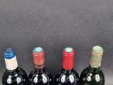 four bottles of wine are lined up in a row