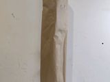 un sac en papier brun posé par terre près d'un mur blanc