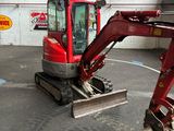 une pelleteuse rouge garée à l'intérieur d'un bâtiment