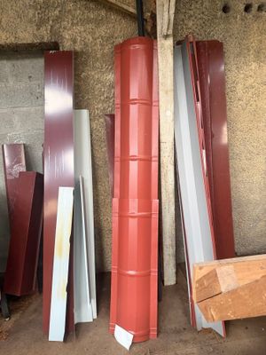 Plusieurs morceaux de métal rouge et blanc sont empilés dans un garage