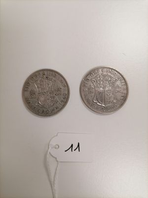 two silver coins sitting next to each other on top of a white surface