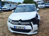 a white car that has been damaged and is sitting in the dirt