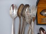 a lot of silver spoons and spoons on the table