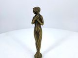 bronze statue of a woman holding her hands to her face