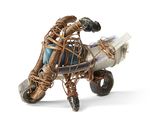 a sculpture of a man riding a motorcycle with a basket on the back of it