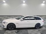 La BMW break blanche est garée sur un sol en carrelage à damier.