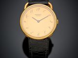 un gros plan d'une montre-bracelet en or avec un bracelet en cuir noir