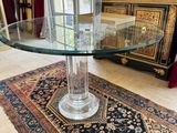 une photo d'une table en verre avec un tapis posé au sol