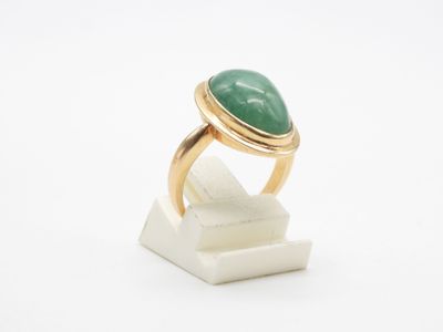 Gros plan sur une bague ornée d'une pierre verte