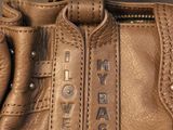 leather handbag with metal hardware and name tag on it