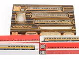 trois boîtes de petits trains jouets posées les unes à côté des autres sur une surface blanche