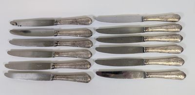 six couteaux sont alignés sur une surface blanche