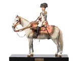 figurine of a man riding a horse on a black base