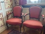 two chairs in the corner of a room with a rug on the floor