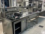 une cuisine avec de nombreux plans de travail en inox