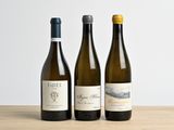trois bouteilles de vin posées sur une table en bois