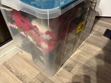 une boîte en plastique posée par terre, avec un gobelet dessus