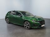 the green car is parked in a large room with a white wall