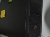 a desktop computer sitting on a desk with a monitor above it