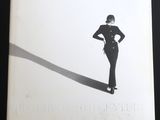 une photo en noir et blanc d'une femme debout devant une ombre