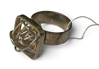 une bague en argent ornée d'un nœud, posée sur un fond blanc