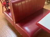 a red booth with two tables and two chairs