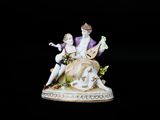 une figurine représentant un homme et une femme assis sur un banc
