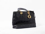 a black handbag with a gold chain on the handle